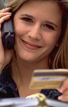 Woman paying for item on telephone with credit card.